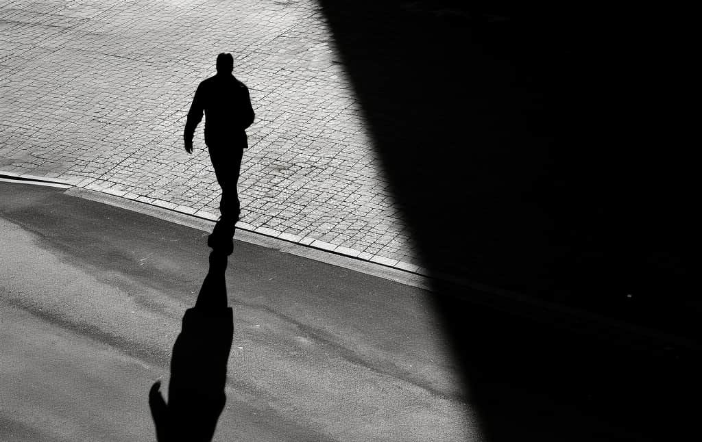 Man on the street walking away in fear and anxiety. 