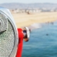 inoculars overlooking a picturesque beach in the distance, symbolizing the importance of seeking professional help for mental health conditions like bipolar disorder treatment in Newport Beach