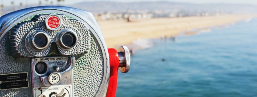 inoculars overlooking a picturesque beach in the distance, symbolizing the importance of seeking professional help for mental health conditions like bipolar disorder treatment in Newport Beach