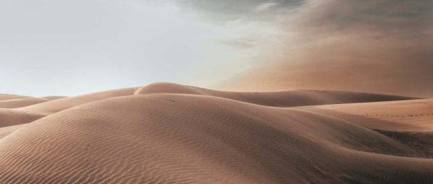 A serene desert landscape, with vast sandy dunes stretching into the distance, symbolizing the journey of navigating through suicidal thoughts towards hope and healing.