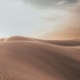 A serene desert landscape, with vast sandy dunes stretching into the distance, symbolizing the journey of navigating through suicidal thoughts towards hope and healing.