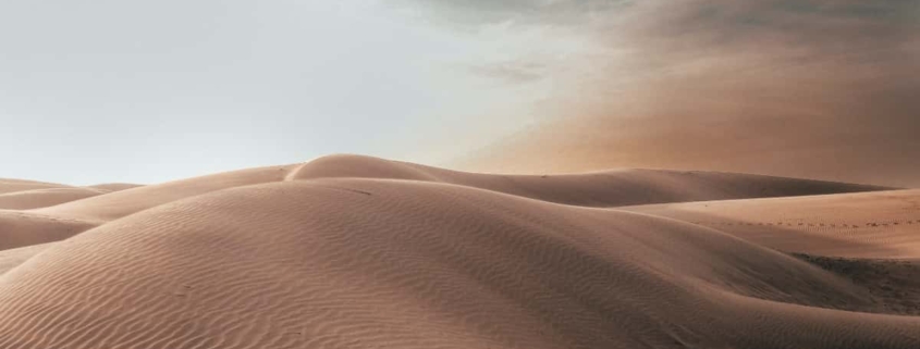 A serene desert landscape, with vast sandy dunes stretching into the distance, symbolizing the journey of navigating through suicidal thoughts towards hope and healing.