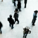 Image of a person standing still in a crowded space while others are walking past, representing social isolation and the effects of Avoidant Personality Disorder (AvPD).