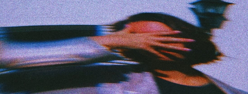 A woman's hand gently covers her face, the image gradually fading into blur, symbolizing the disorientation and confusion often associated with experiencing gaslighting.