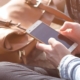 Anxious woman sitting on a sidewalk, intently looking at her cell phone, illustrating the concept of Nomophobia.