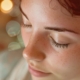 Close-up of a woman with closed eyes practicing Reiki for anxiety relief, with soft, blurry lights in the background creating a serene and calming atmosphere.