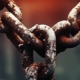 Rusty chains illuminated by a soft red light in the background, visually metaphorizing the concept of 'what is a trauma bond.'