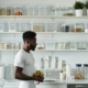 A man stands in a kitchen beside a counter displaying meticulously organized food containers illustrating can OCD be cured in a healthy way.