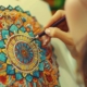 Close-up image of a woman coloring a mandala symbolizing the use of art therapy in neurodivergent mental health care.