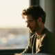 A professional working quietly alone at a desk near a window, illustrating jobs for people with social anxiety.