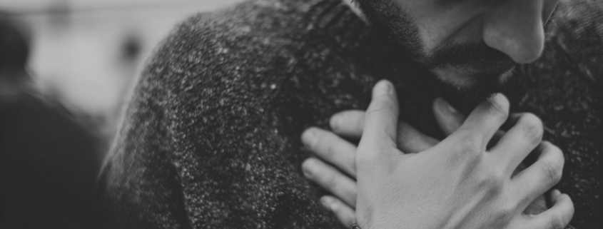 A man holds his hands against his chest in an article about ketamine for depression.