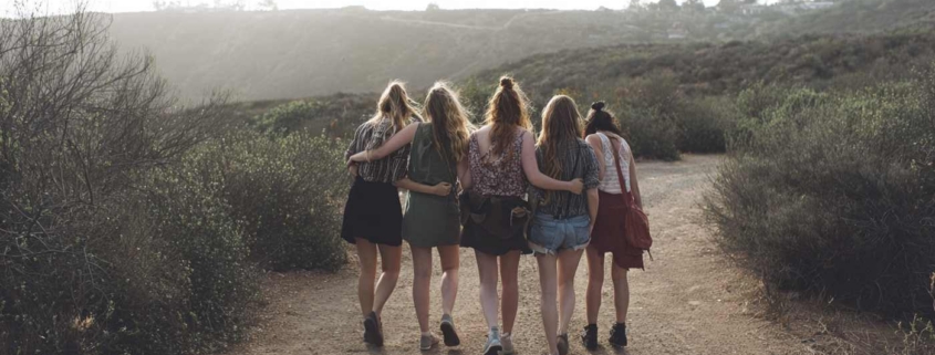 Five women walk together on a trail, illustrating connection and support during a residential mental health transition.